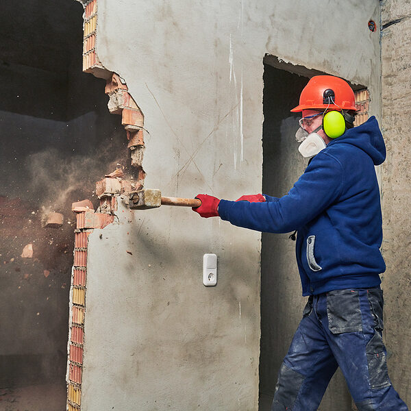 demolition work and rearrangement. worker with sledgehammer destroying wall